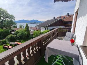 a balcony with a table and a view of the water at Gästehaus Radlerhof in Gstadt am Chiemsee