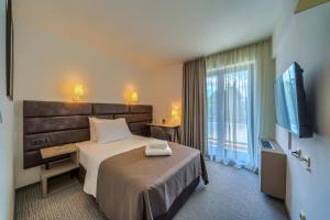 a hotel room with a bed and a flat screen tv at Hotel Alkar - Family Friendly Hotel with Pool in Sinj, Dalmatia in Sinj