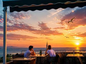 two people sitting at tables watching the sunset at Ayasofya Hotel - Special Class in Istanbul