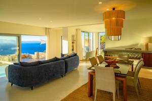 a living room with a blue couch and a table at Luxury Villa with Panoramic Sea Views in Thólos