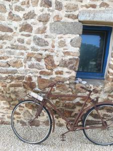 a bike parked in front of a stone wall at La Chaumière en Bellevue in Muzillac