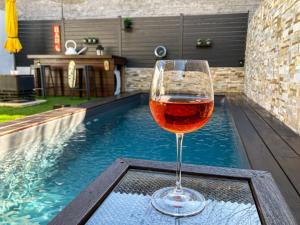 a glass of wine sitting on a table next to a swimming pool at Maison Paillette à Saint Saturnin in Saint-Saturnin-lès-Avignon