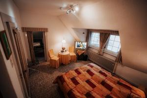 a hotel room with a bed and a table and window at Landhotel Herscheider Mühle in Herscheid