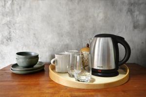 a coffee maker and cups on a wooden tray at Boutique Jungle Villa - Baan ChaOm in Ko Lanta