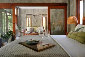 a bedroom with a bed with two wine glasses on it at Boutique Jungle Villa - Baan ChaOm in Ko Lanta