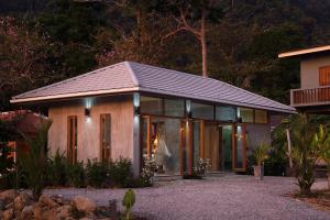 a house with glass doors and a roof at Boutique Jungle Villa - Baan ChaOm in Ko Lanta