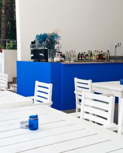 a group of white tables and chairs with a blue at Residence Kullat in Velipojë