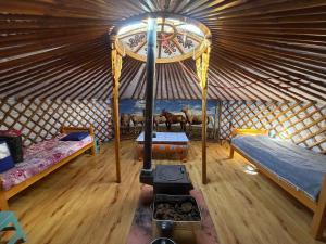 a room with two beds in a yurt at Nomad Equestrian Stable in Dzuunmod