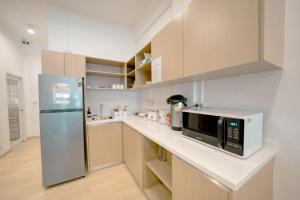 a kitchen with a refrigerator and a microwave at The Ostel Hostel Bangkok in Bangkok