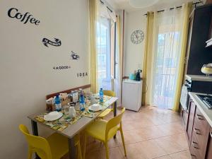 a kitchen with a table with yellow chairs and a table and a tableablish at Affittacamere Il Veliero in Levanto +40 photos
