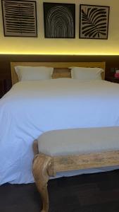 a bed with white sheets and a wooden foot board at جناح ريفي in Al Yamāmah