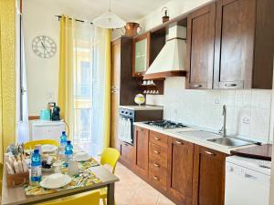 a kitchen with wooden cabinets and a table with a sink at Affittacamere Il Veliero in Levanto