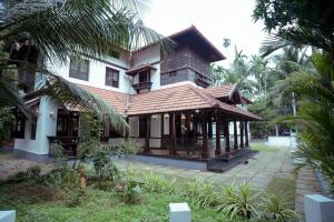 a house with a building with a courtyard at Poomuttathillam in Kunnamangalam