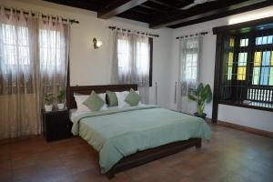 a bedroom with a large bed in a room with windows at Poomuttathillam in Kunnamangalam