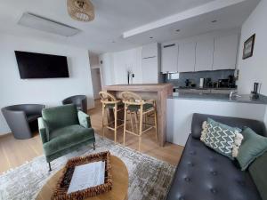 a living room with a couch and a kitchen at Chic & Cozy Lake View Apartment in Seeboden