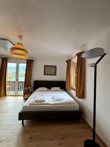 a bedroom with a bed and a large window at Chic & Cozy Lake View Apartment in Seeboden
