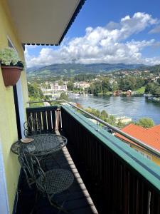 a balcony with a table and chairs and a view of a river at Chic & Cozy Lake View Apartment in Seeboden