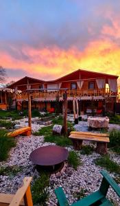 a lodge with a table and benches in front of it at Green Owl in Dedoplis Tskaro
