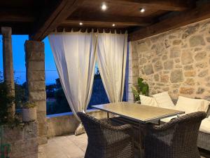 a table and chairs on a patio with a window at Villa Anica Dubrovnik - luxurious with a sea view in Dubrovnik