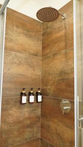 a shower with three bottles of soap on a wall at Casa Panerole in Novello +31 photos
