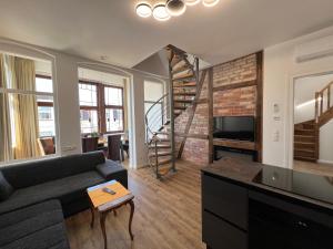 a living room with a couch and a spiral staircase at Villa Pippingsburg am Strand in Ahlbeck