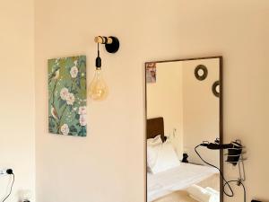 a mirror in a bedroom with a bed and a lamp at Guesthouse Historical Palacinho de São Antonio in Birgu +66 photos