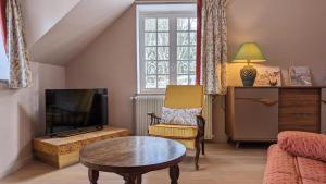 a living room with a couch and a tv and a table at Le Mariotte in Pont-et-Massène