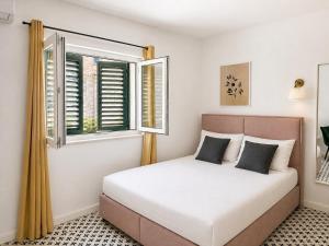 a bedroom with a bed and a window at Stella Apartments in Kaštela