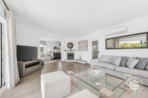 a white living room with a couch and a table at Villa Benjamin - Vale do Lobo in Vale do Lobo