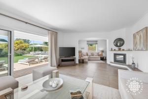 a living room filled with furniture and a fireplace at Villa Benjamin - Vale do Lobo in Vale do Lobo