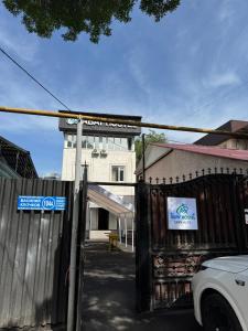 a gate in front of a building with a sign on it at Abay Hostel in Almaty +4 photos