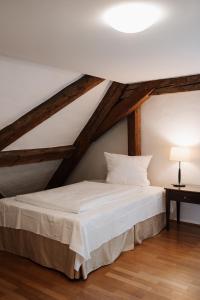 a bedroom with a white bed in a attic at Schloss Maierhofen in Painten