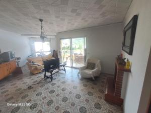 a living room with a couch and a chair and a television at Mountain View Village Life in Bárig