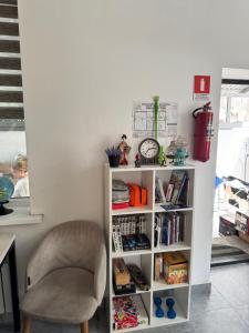 a book shelf with a chair and a clock at Abay Hostel in Almaty