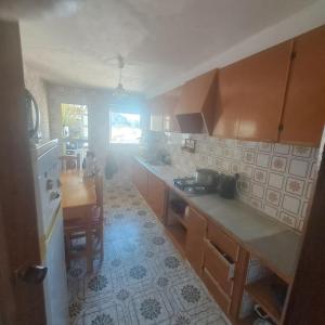 a kitchen with wooden cabinets and a counter top at Mountain View Village Life in Bárig