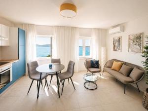 a living room with a couch and a table and chairs at Stella Apartments in Kaštela