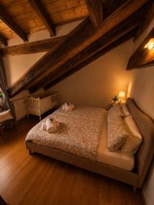 a bedroom with a bed with two stuffed animals on it at Casa Zarabara in Arta Terme