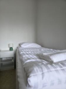 an unmade bed in a bedroom with a night stand at Kotoisa 1 in Seinäjoki +1 photo