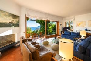a living room with a blue couch and a fireplace at Hostdomus - Villa Gabriella with private pool in Alassio