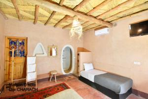 a bedroom with a bed in a room with a ceiling at Maison d hôtes Dar Charach in Ouarzazate