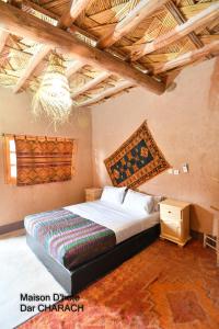 a bedroom with a bed and a chandelier at Maison d hôtes Dar Charach in Ouarzazate