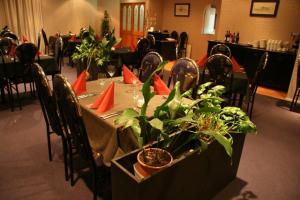 a dining room with a table with plants on it at Central Park Motor Inn in Taumarunui