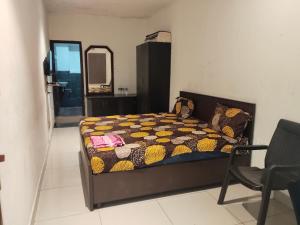 a bedroom with a bed and a mirror and a chair at AB Merridien in Coimbatore