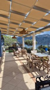 a patio with tables and chairs and a view of the water at Villa Anna in Skaliá