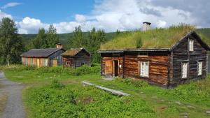 an old house with a grass roof on top of it at Saxnäsgården Hotell in Saxnäs