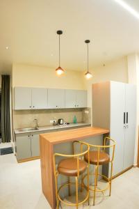 a kitchen with two bar stools and a counter at Gems Munnar in Anachal