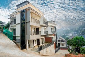 a building on top of a hill with a cloudy sky at Gems Munnar in Anachal