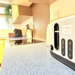 a kitchen with a washer and dryer on the floor at The Forgate exchange in Worcester