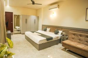 a bedroom with a large bed and a chair at Gems Munnar in Anachal