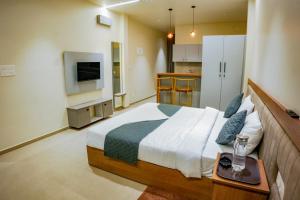 a bedroom with a large bed and a television at Gems Munnar in Anachal
